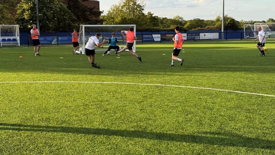 A football match in progress on an all-weather pitch