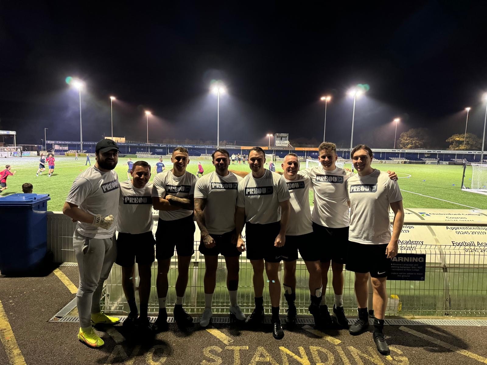 The Preou football team lined up beside a floodlit pitch