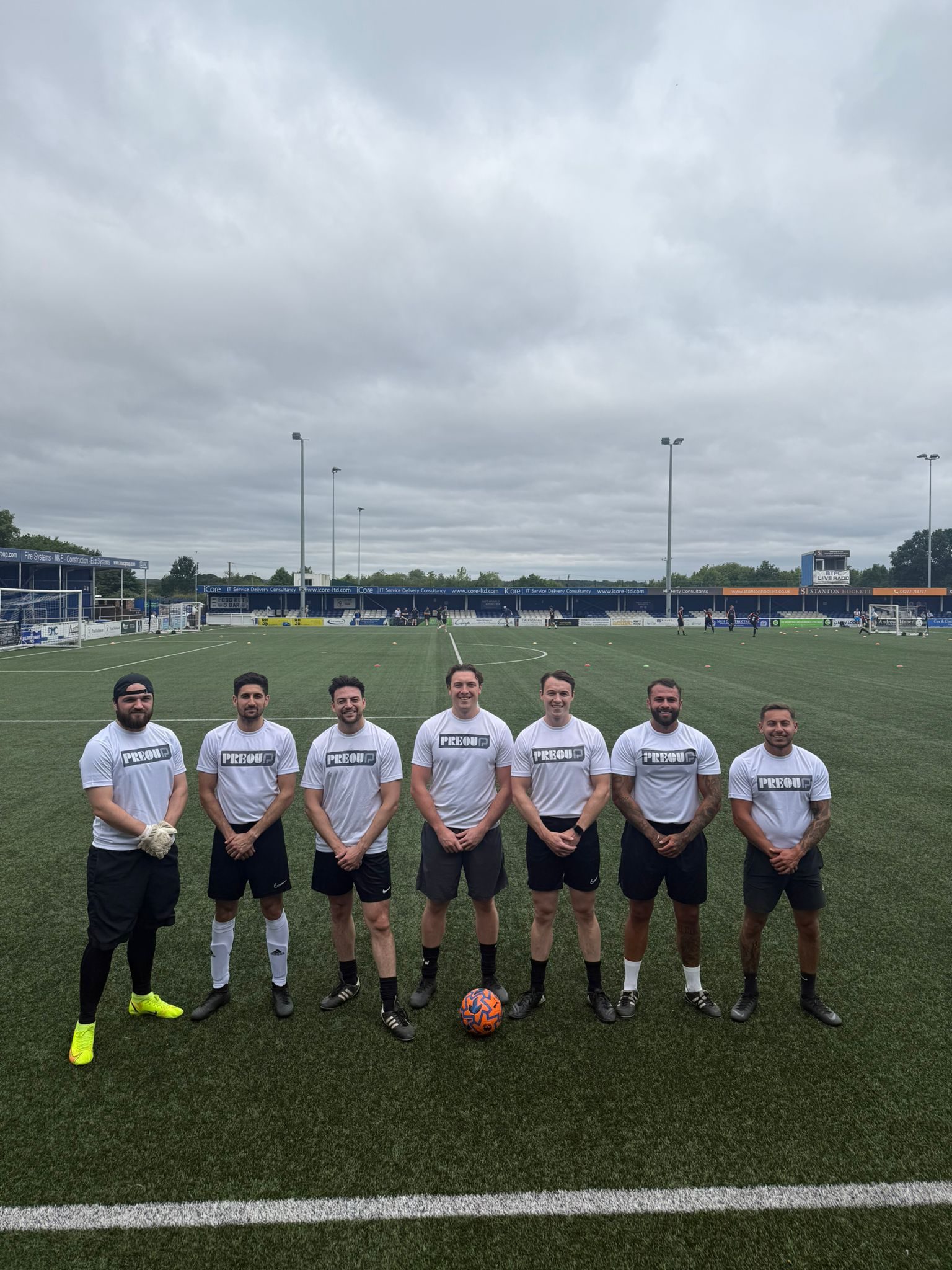 The Preou football team in white Preou shirts on an all-weather pitch