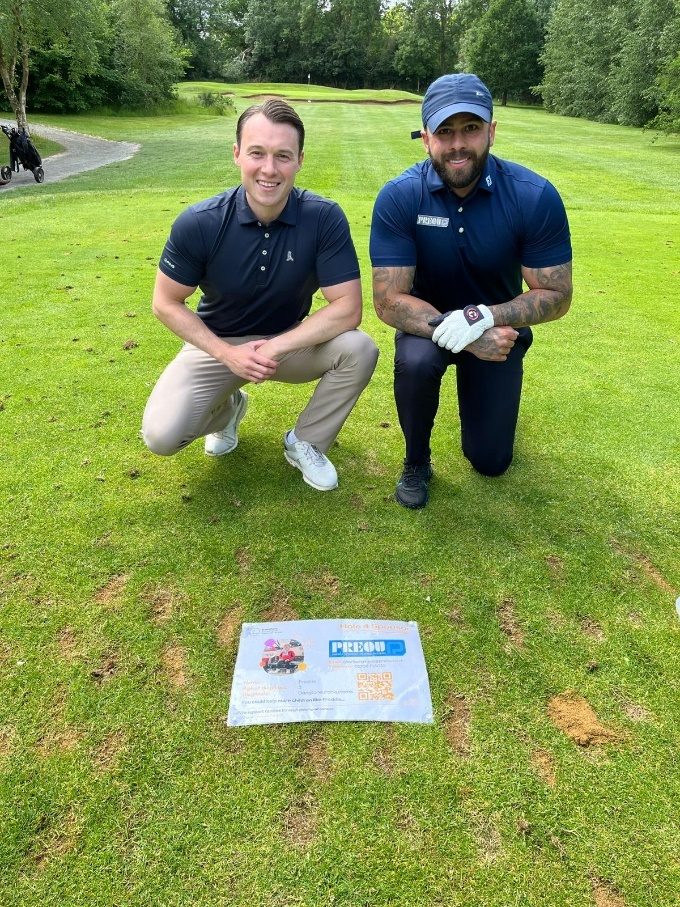 Two of the Preou team kneeling on the golf course