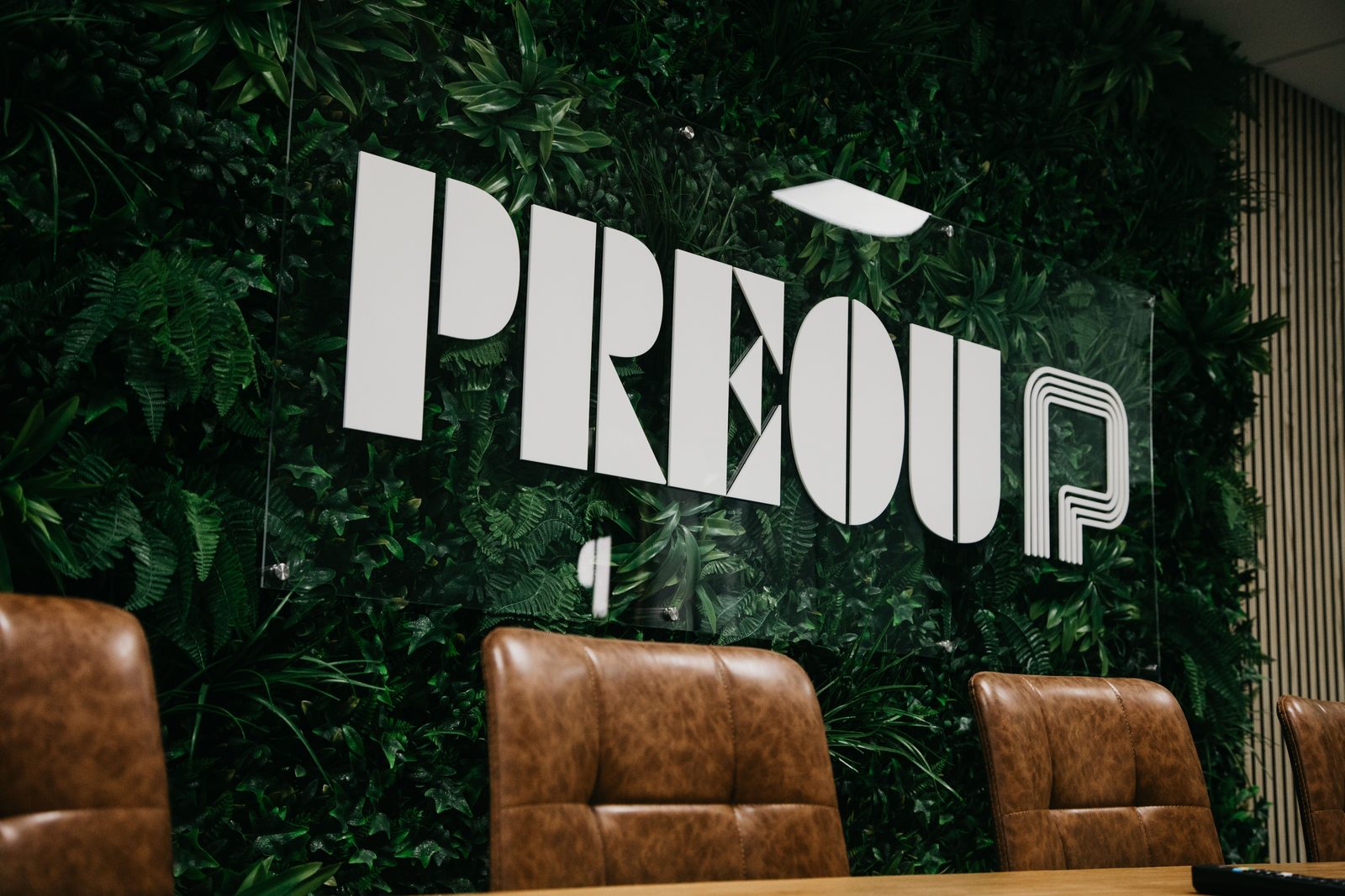 The Preou logo on a planted wall in the boardroom at Radford Crescent