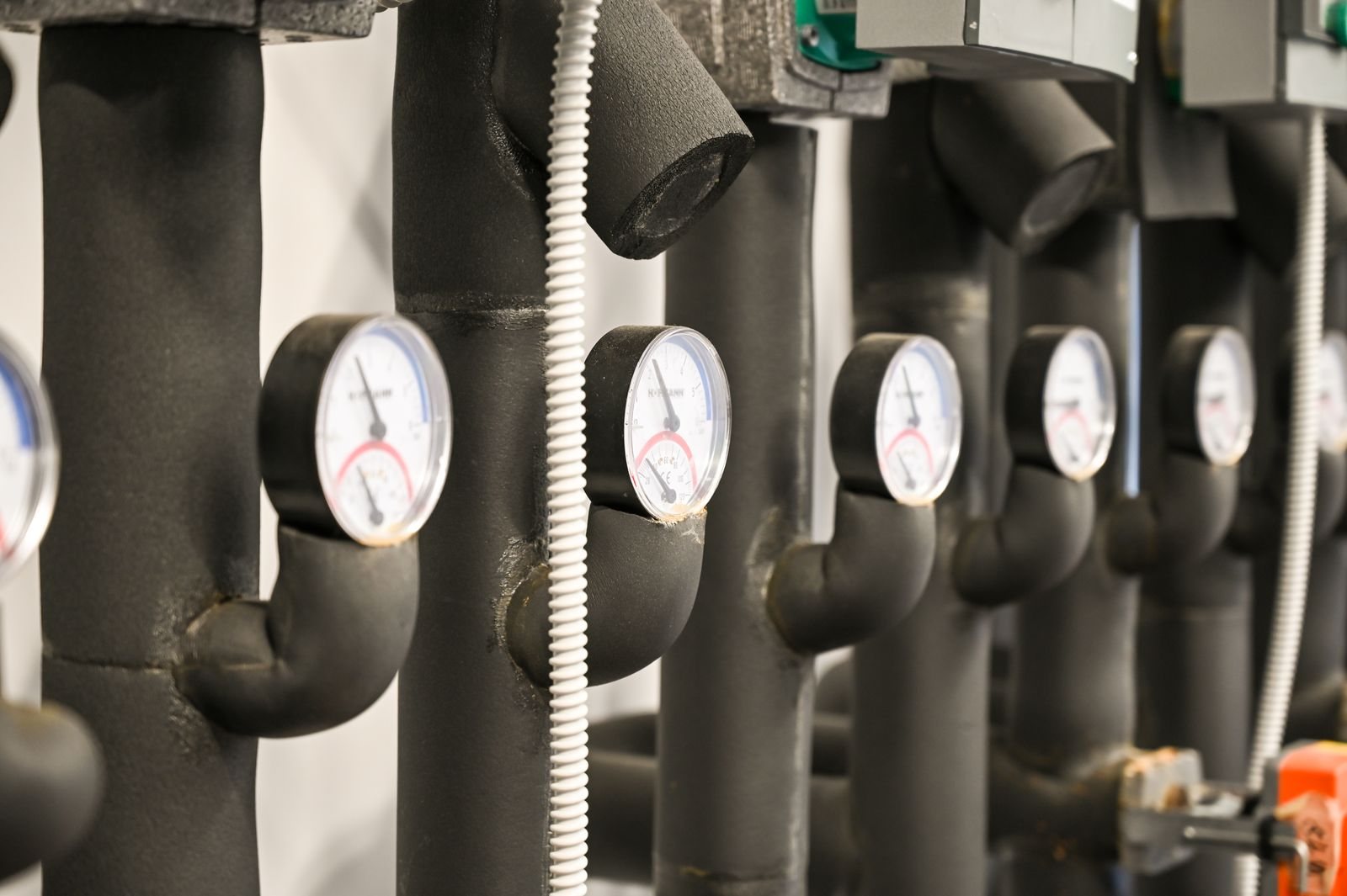 Insulated pipework with temperature gauges in a plant room